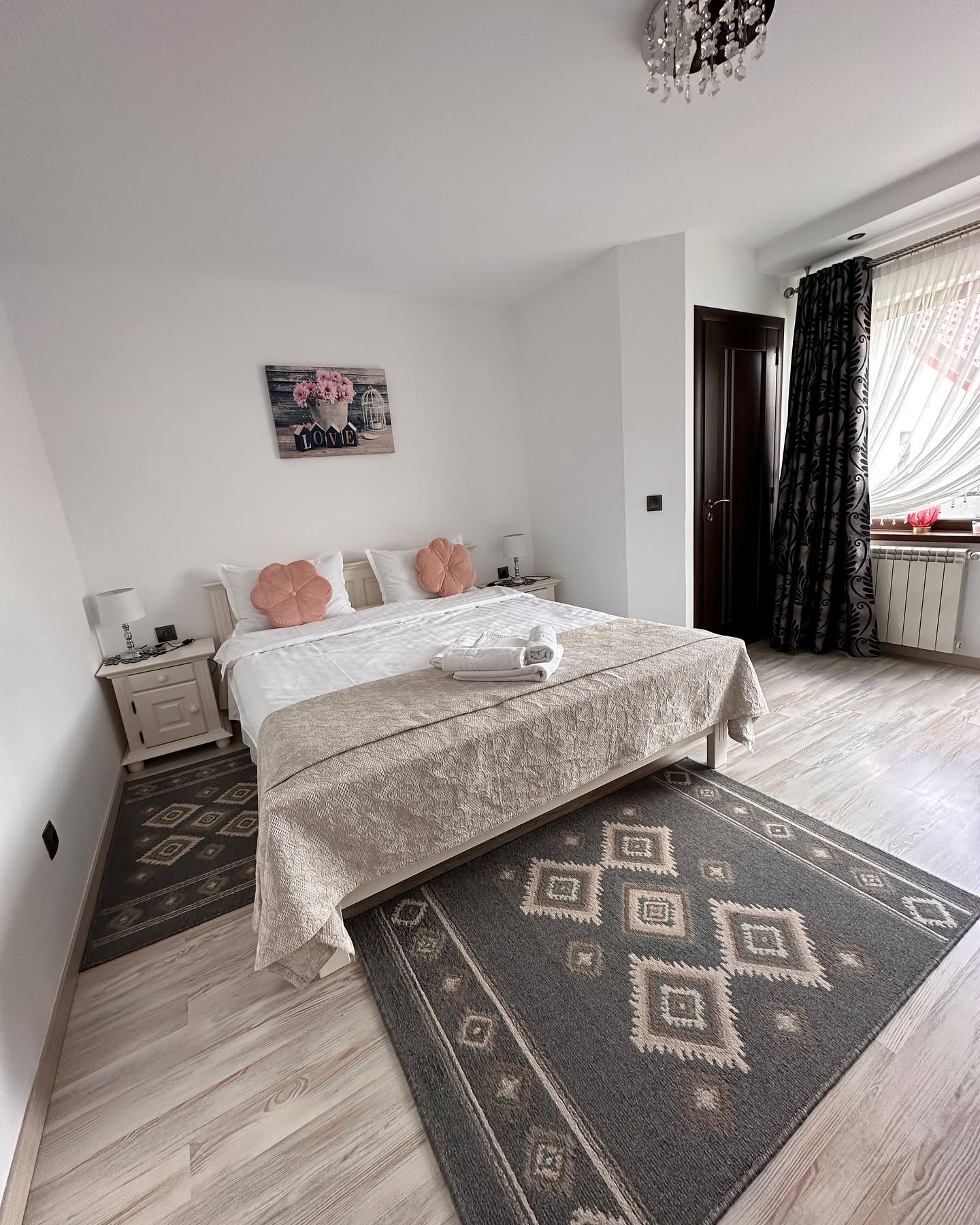 Cameră dublă cu pat matrimonial, mobilier alb și covoare tradiționale